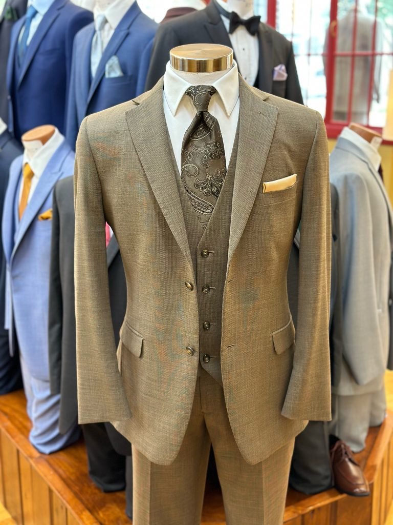 tan suit on display with a white shit and dark tie