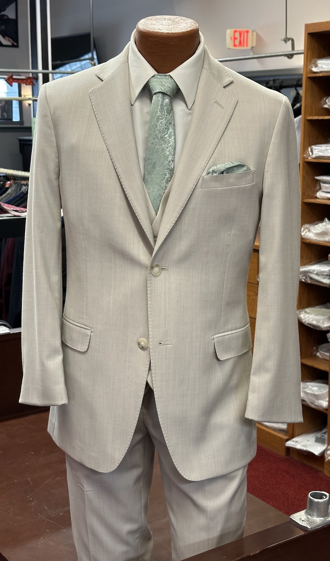 tan suit with light green tie and handkerchief